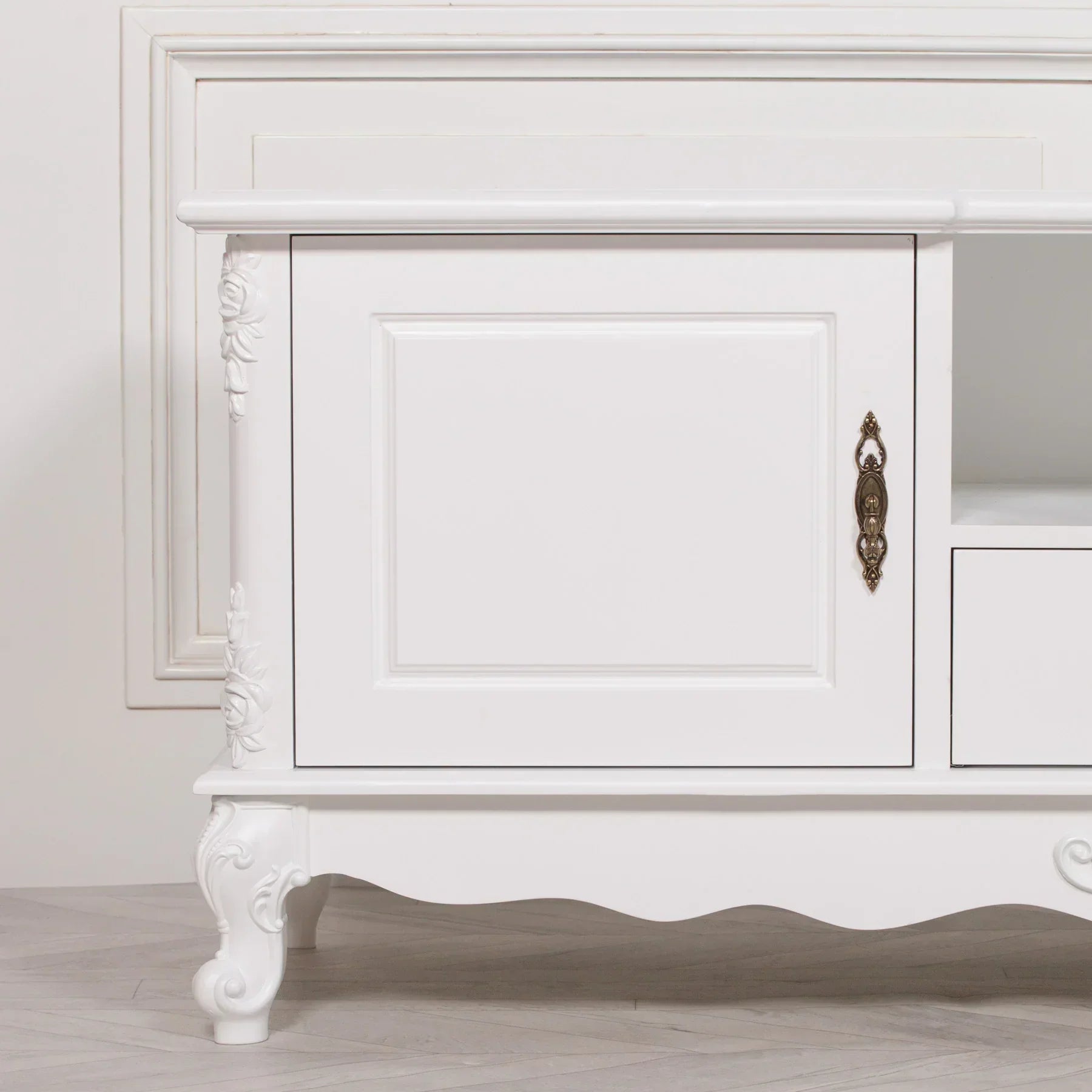 White wooden TV unit with ornate legs, rose carvings, and antique brass handle detail