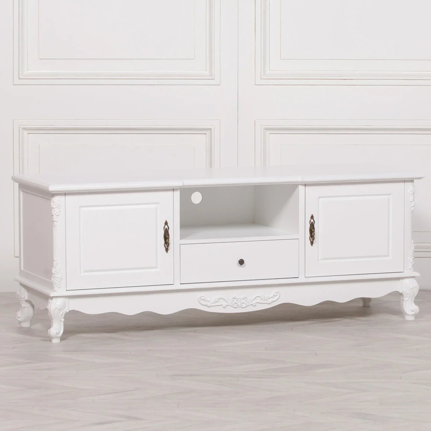 White wooden TV unit with two doors, central drawer, and carved decorative details