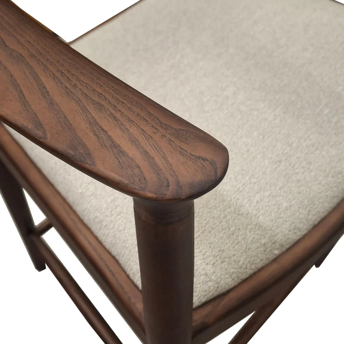 Fern barstool closeup showing dark wood armrest and light upholstered seat