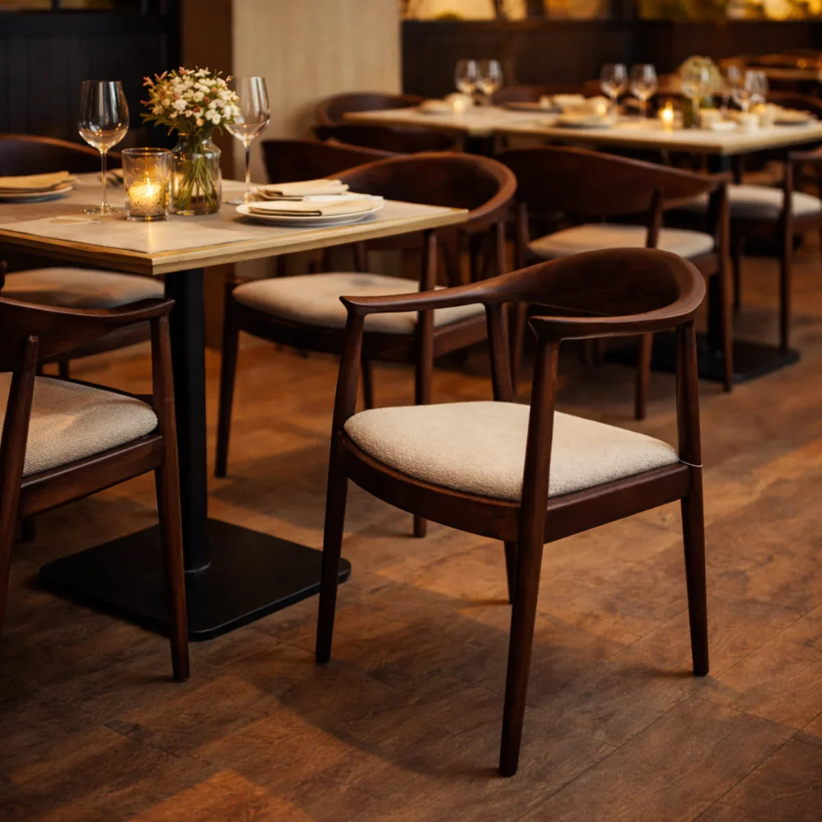 Fern chair with curved wooden frame and beige seat at a set dining table