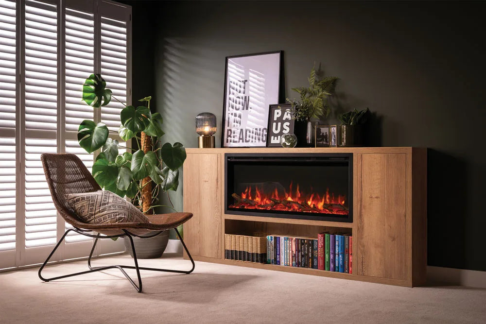 Atmos electric fire installed in a stylish living room with a wooden cabinet, plants, and a comfortable chair.