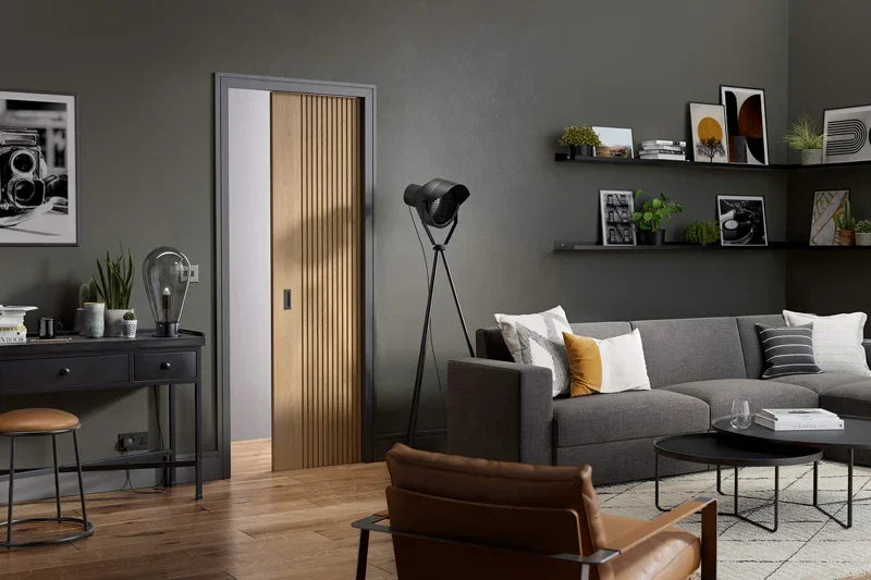 Oak fluted pocket door set in modern living room with grey sofa and black accents