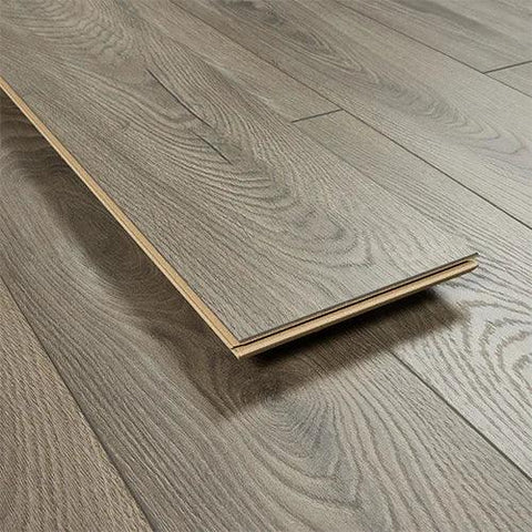 Fossil oak laminate flooring plank with realistic wood grain finish on installed floor