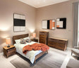Wooden double bed with matching bedside tables, chest of drawers and sideboard in modern bedroom