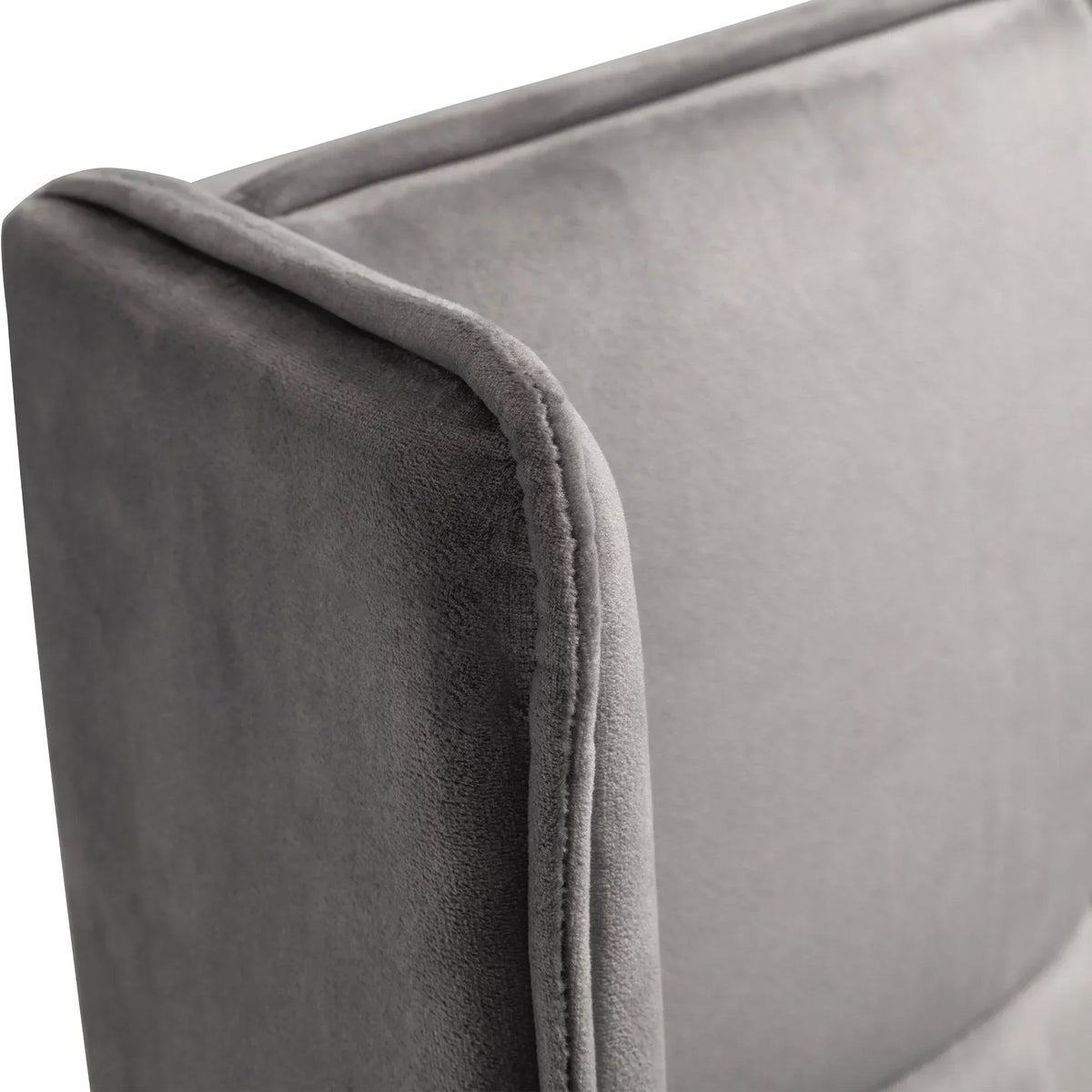 Close-up of grey velvet ottoman bed headboard upholstery and piping detail