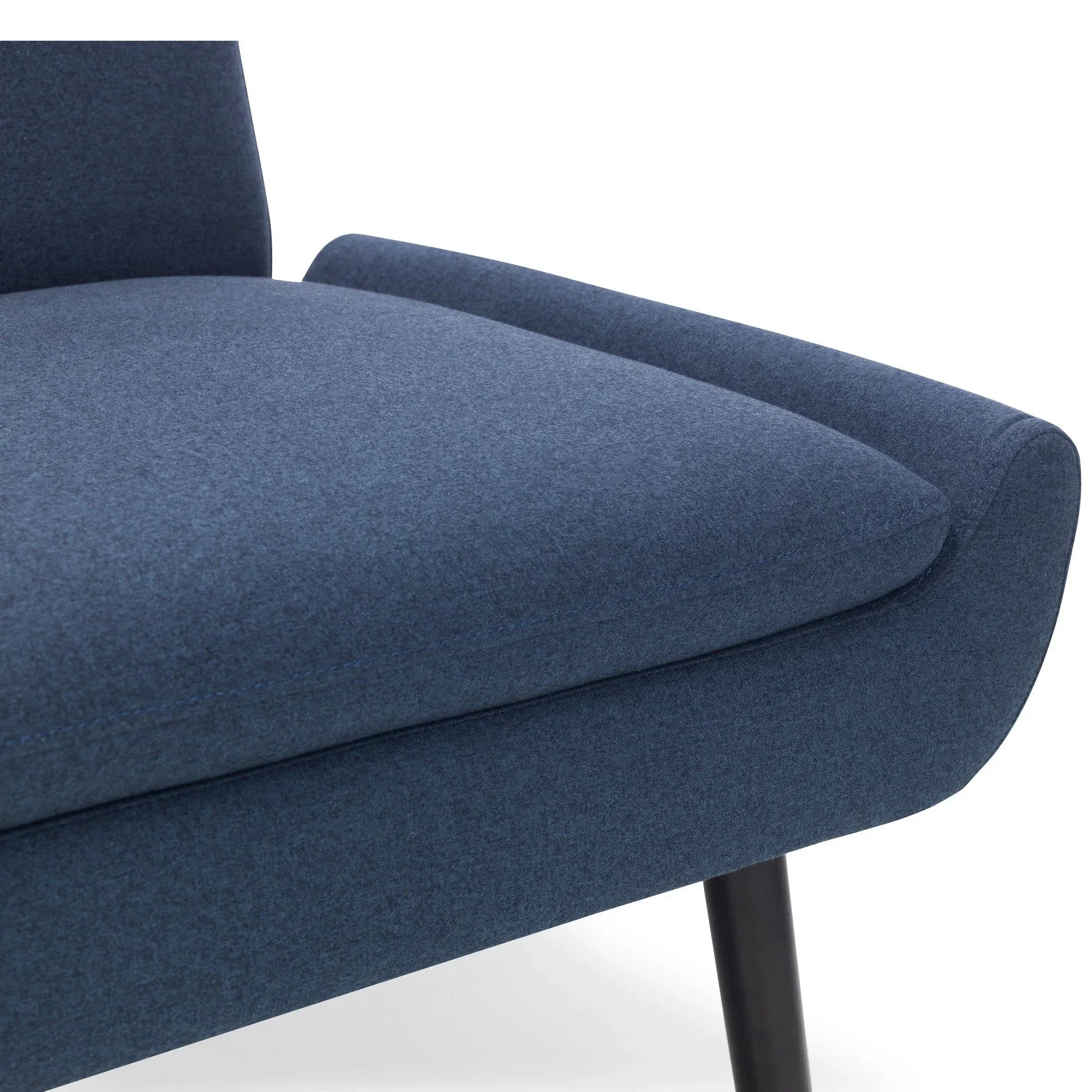 Close-up of blue fabric armchair seat with wooden leg and curved armrest