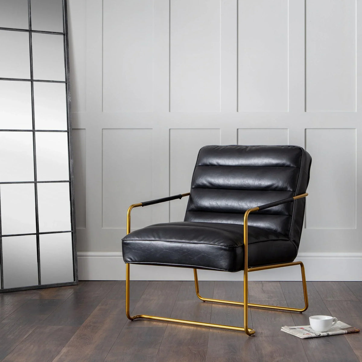 Black leather accent chair with gold metal frame in modern living room setting