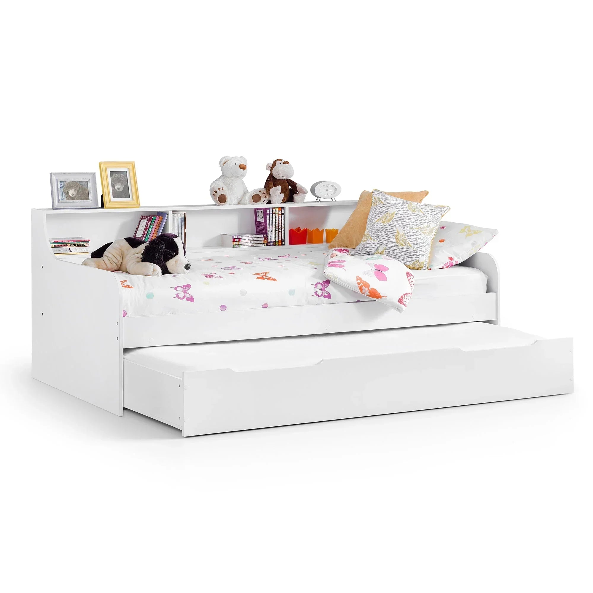 White daybed with pull-out trundle, open shelving, bedding, stuffed toys and books
