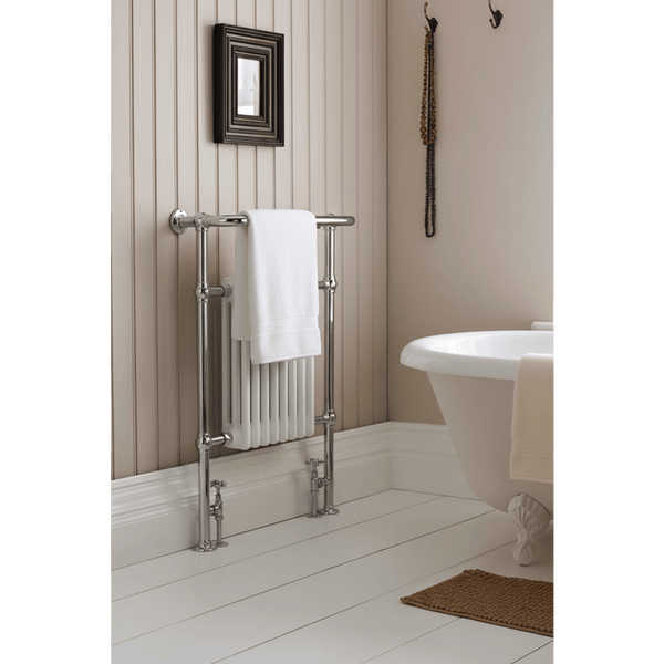 Bathroom with a towel rack, white bathtub, and decorative elements.