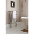 Bathroom with a towel rack, white bathtub, and decorative elements.