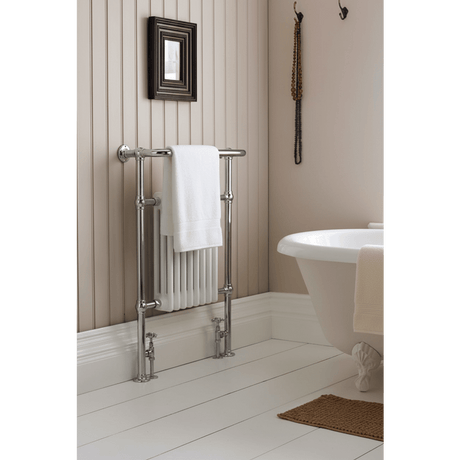 Bathroom with a towel rack, white bathtub, and decorative elements.