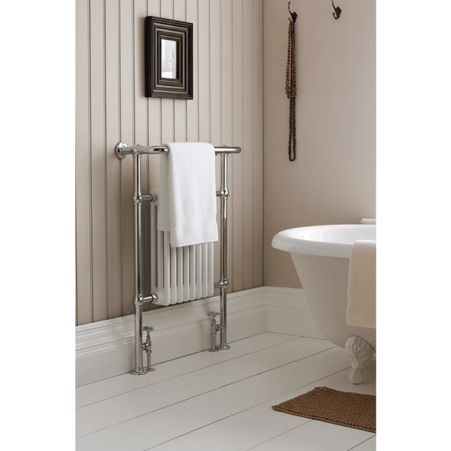 Bathroom with a towel rack, white bathtub, and decorative elements.