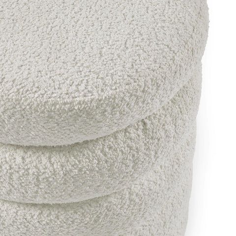 Close up of boucle fabric ottoman in cream with curved, layered design