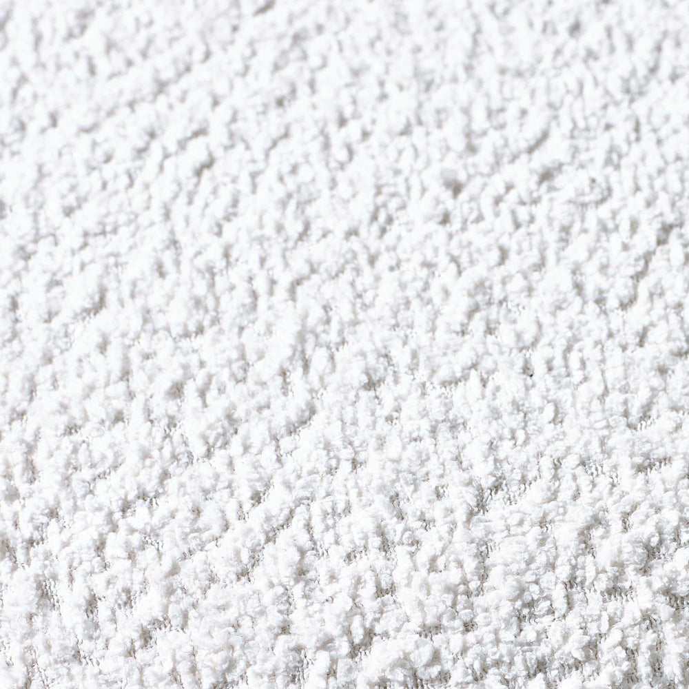 Close-up of soft white textured rug surface showing plush carpet fibers