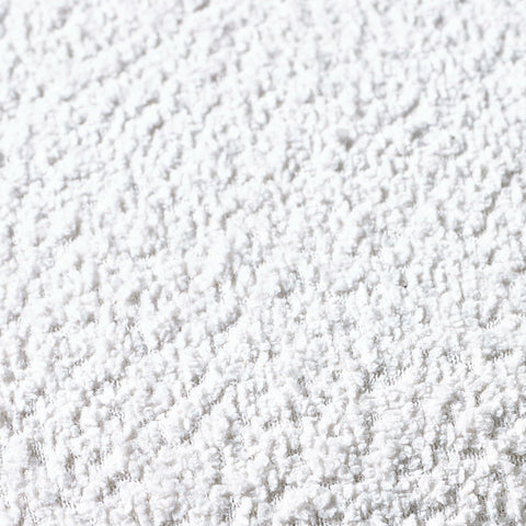 Close-up of soft white textured rug surface showing plush carpet fibers