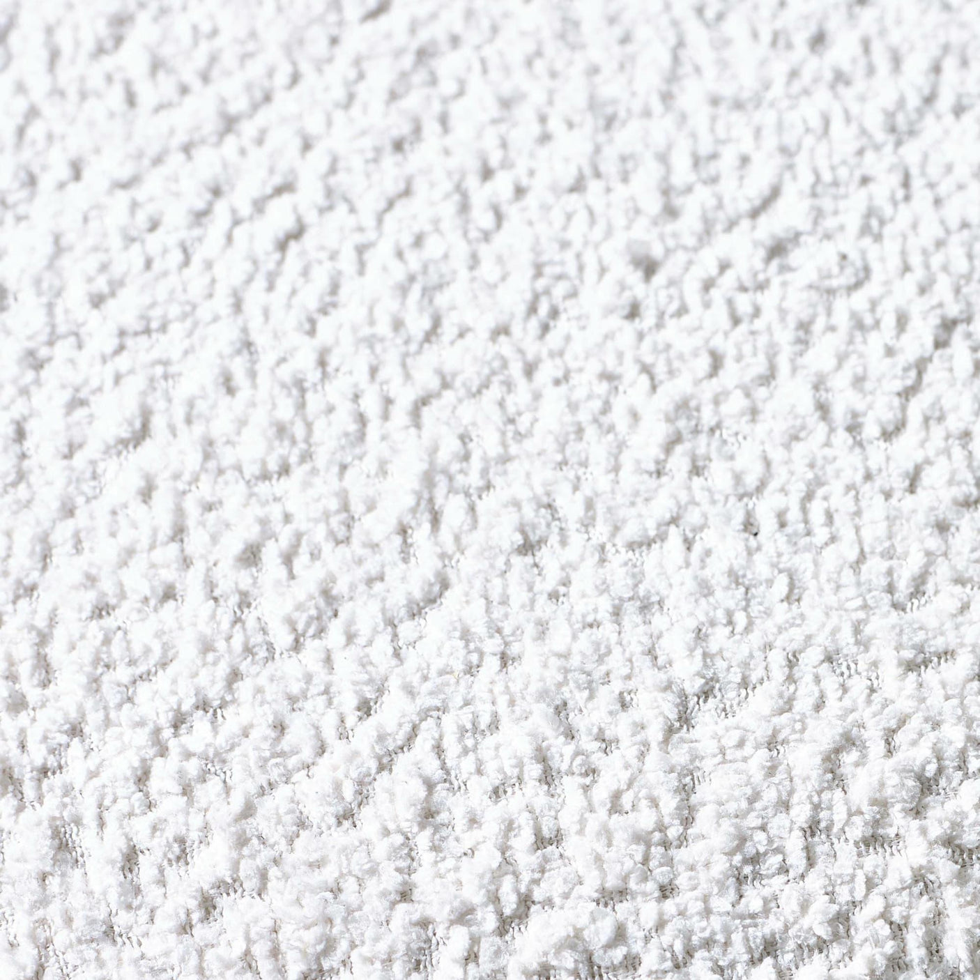 Close-up of soft white textured rug surface showing plush carpet fibers