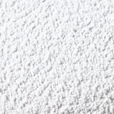 Close-up of soft white textured rug surface showing plush carpet fibers