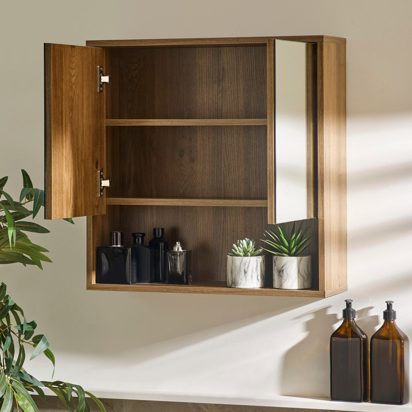 Brown wood bathroom cabinet with both doors open, revealing two shelves behind left door and mirror on right door.