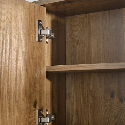 Close-up of oak wood bathroom cabinet interior with metal hinges and single shelf in natural wood finish