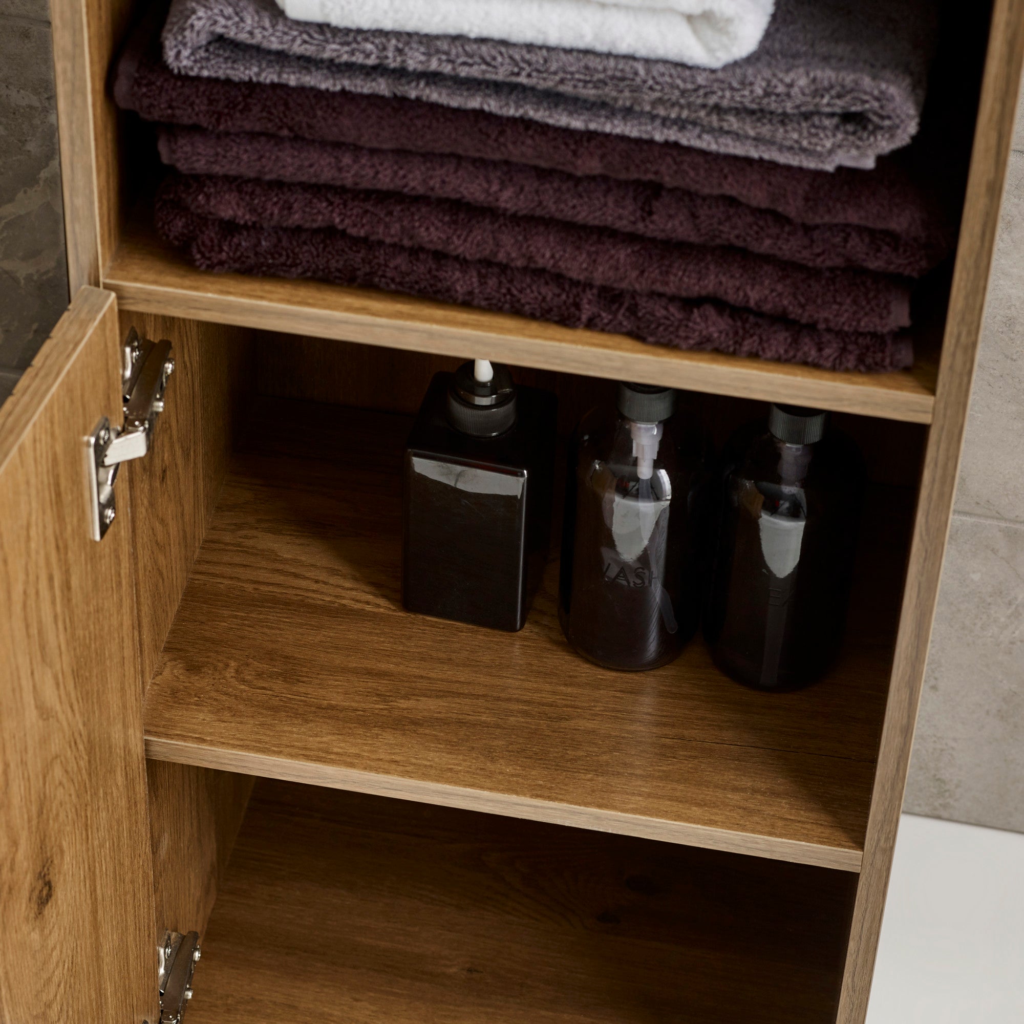 Close-up of vertical black metal handle mounted on slatted wood cabinet door, walnut finish