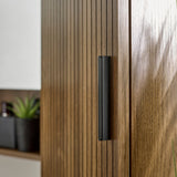 Tall walnut bathroom cabinet with textured slatted doors and open shelves displayed in modern bathroom setting