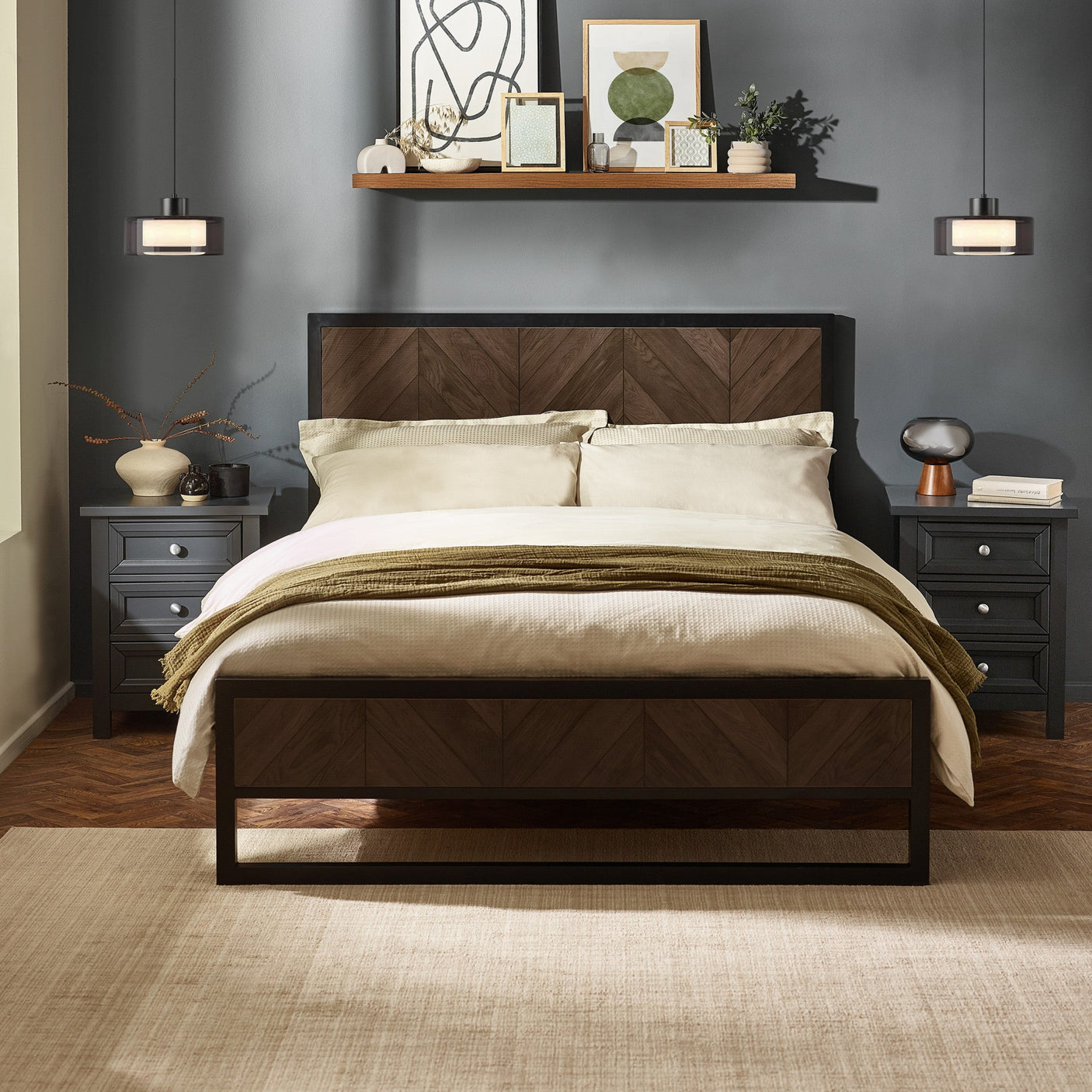 Herringbone patterned headboard and footboard bed in dark wood and black metal frame with bedding in a decorated gray room
