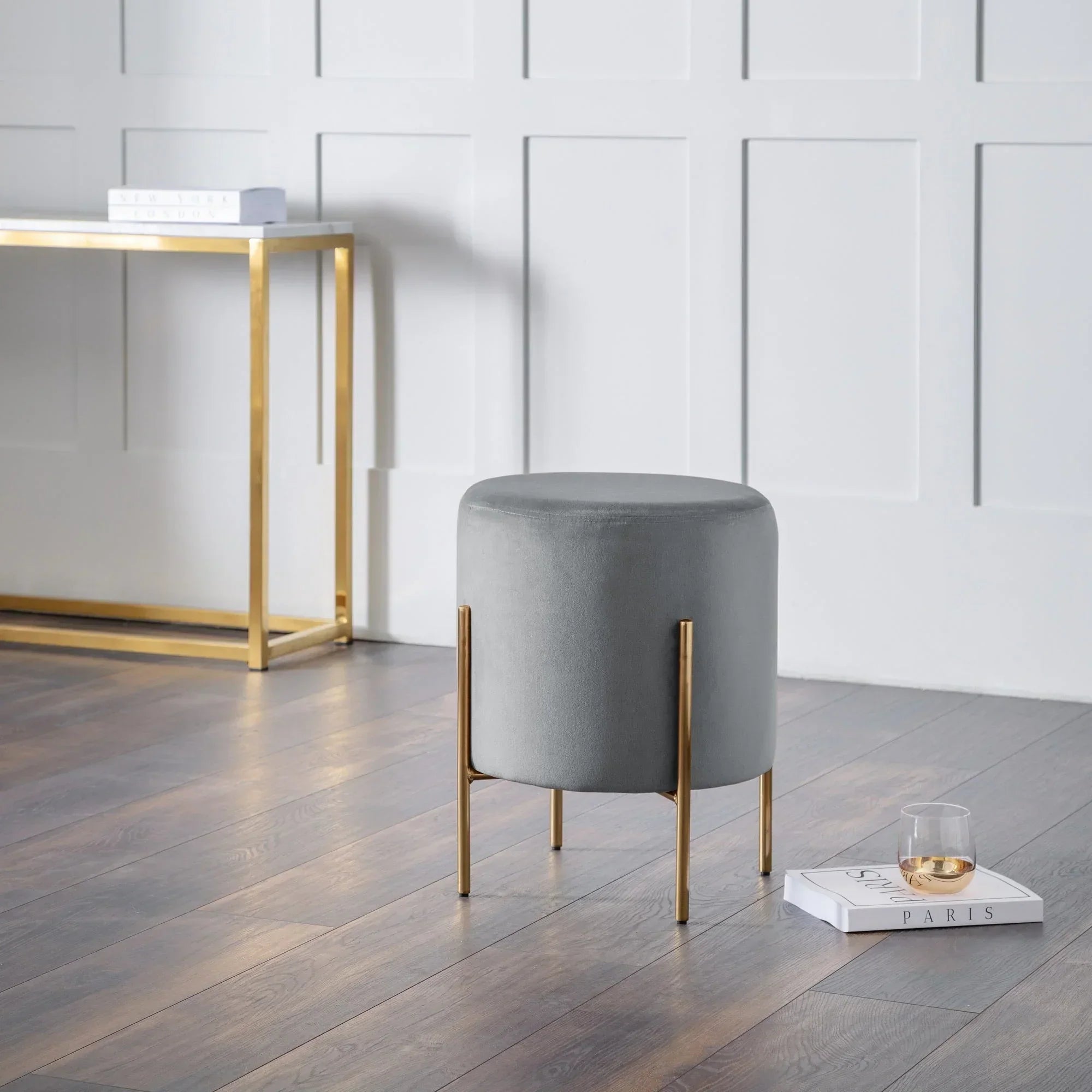 Grey velvet Harrogate stool with gold legs in modern living room beside console table