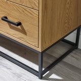 Oak wood drawer unit with black metal handle and frame on grey laminate floor