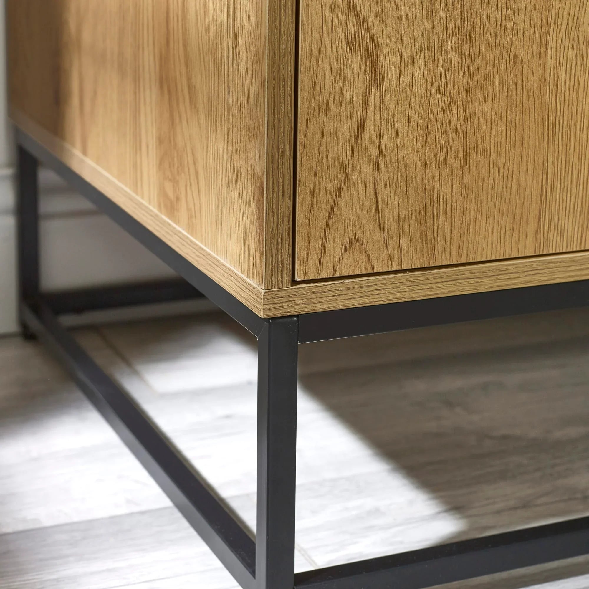 Close up of wood sideboard with black metal legs on light laminate floor