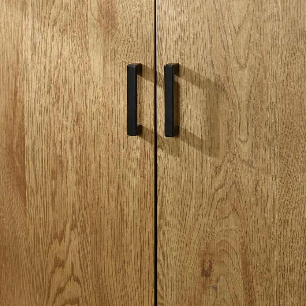 Oak effect wardrobe doors with black metal handles, close-up view of wood grain texture
