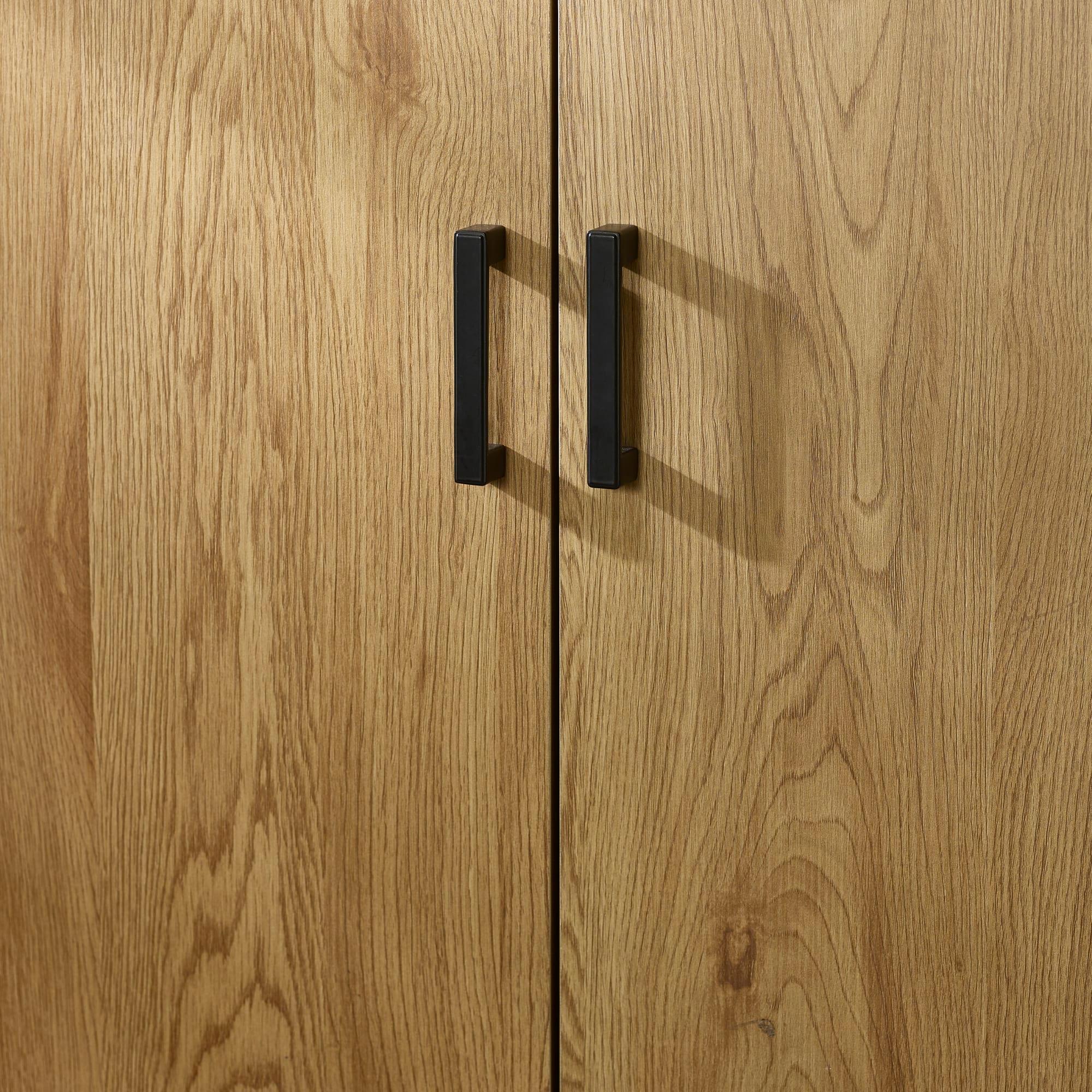 Oak effect wardrobe doors with black metal handles, close-up view of wood grain texture