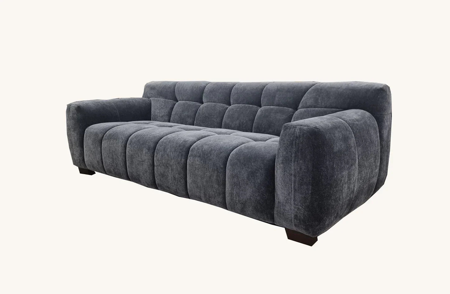 Charcoal grey fabric sofa with deep tufted cushions and wide armrests on white background