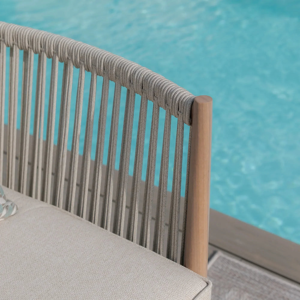 Outdoor rope lounge chair with beige cushion beside swimming pool