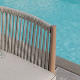 Outdoor rope lounge chair with beige cushion beside swimming pool