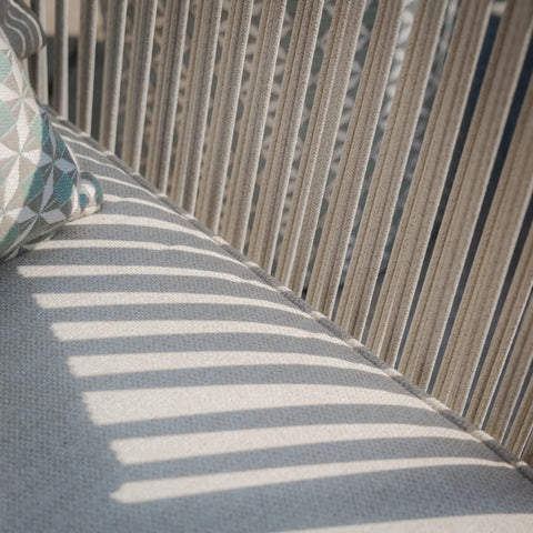 Beige fabric outdoor sofa seat with vertical rope backrest and geometric cushion corner