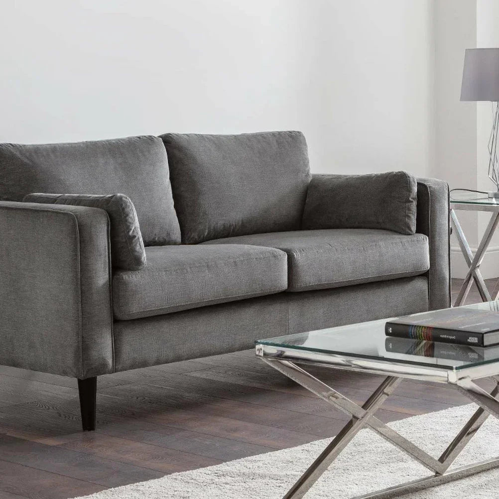 Dark grey chenille 2 seater sofa in modern living room with glass coffee table