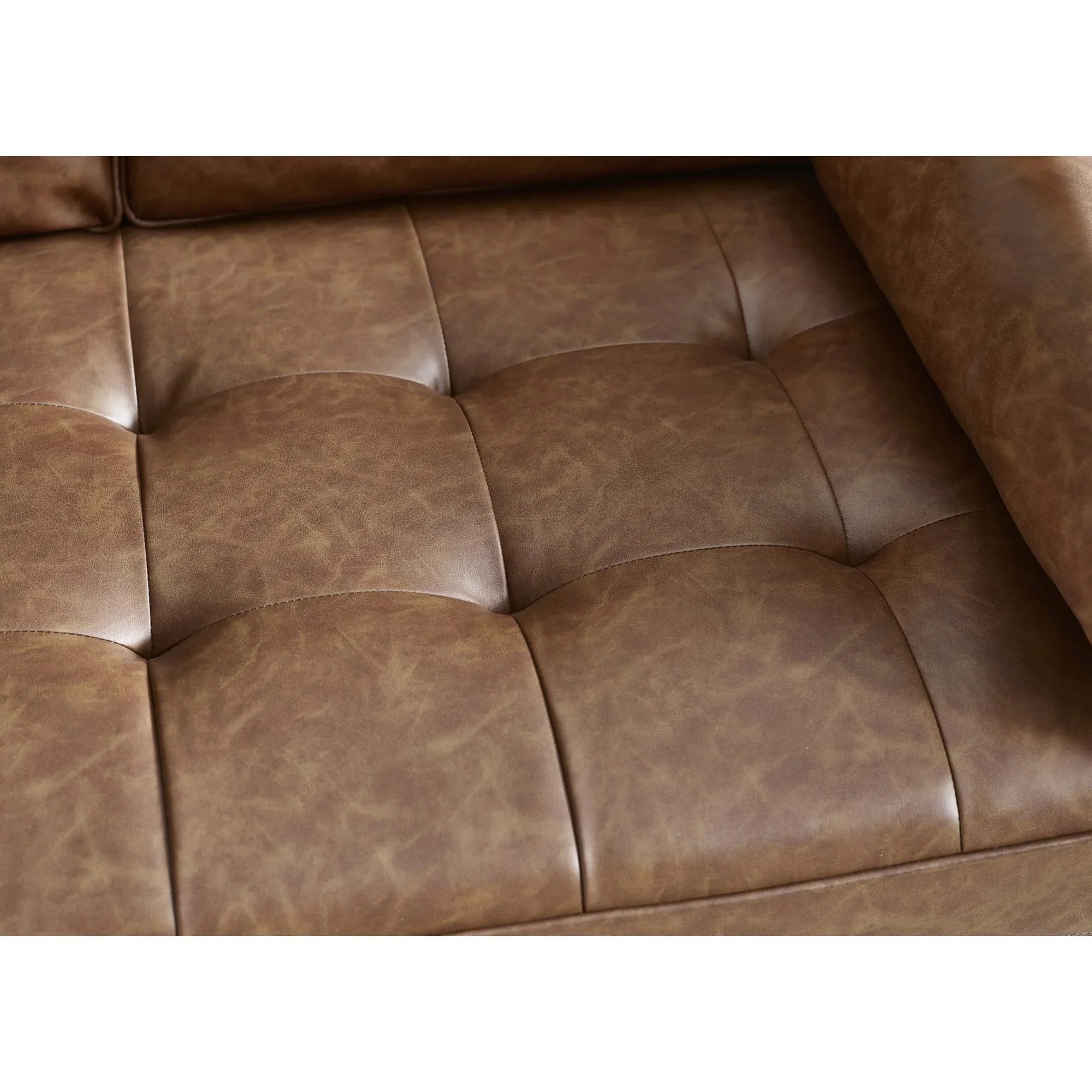 Closeup of brown leather sofa seat cushion with tufted stitching detail