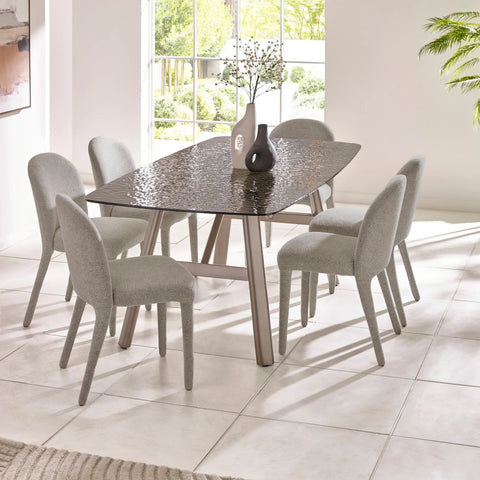 Glass dining table with six grey upholstered chairs in modern bright dining room
