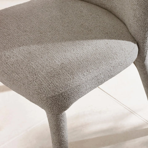Light grey fabric dining chair seat and legs close-up on tiled floor