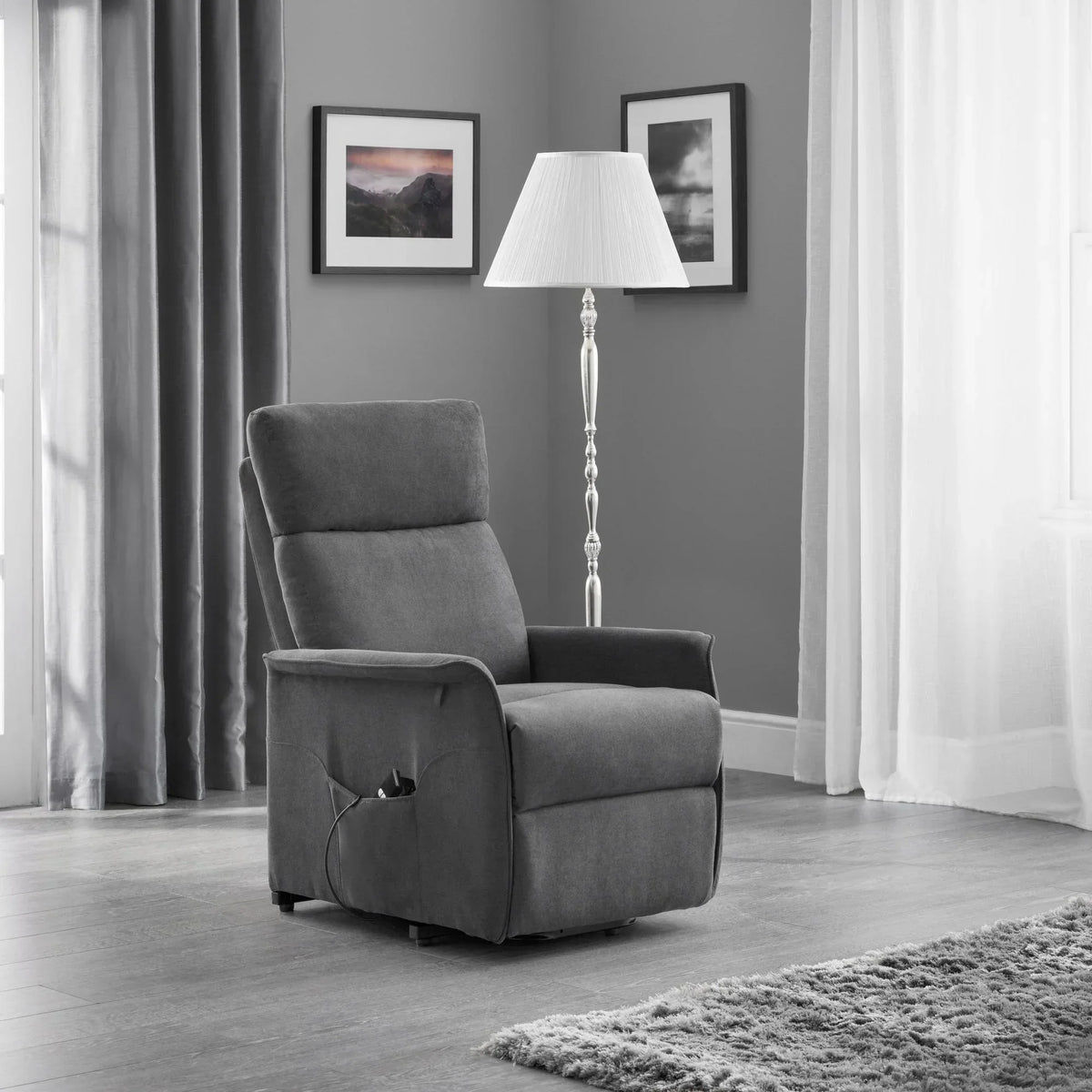 Charcoal rise recliner chair with remote in modern living room, floor lamp and wall art nearby