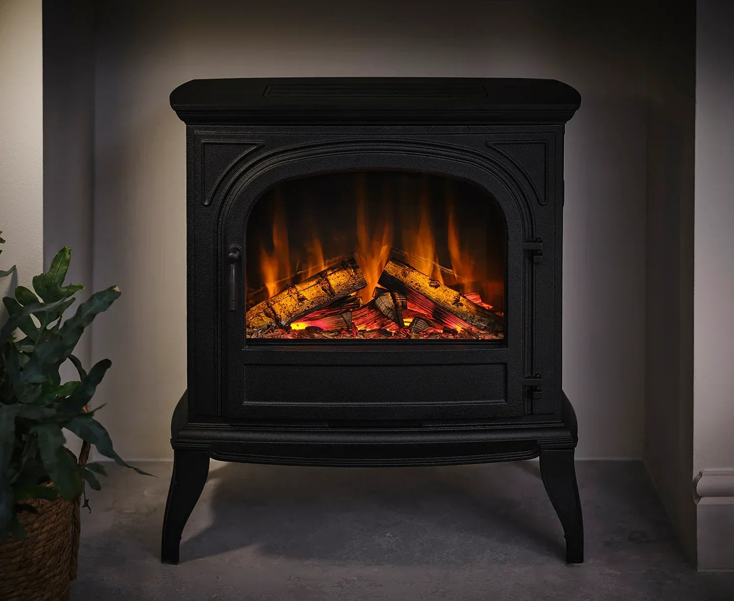 Black electric stove heater with realistic flame effect and log detail on grey floor