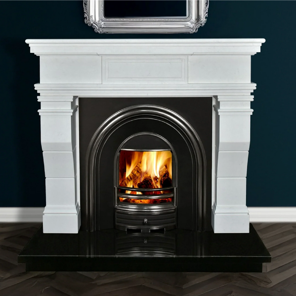 White marble fireplace with black arched insert and real wood fire on dark tile hearth