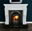 White marble fireplace with black arched insert and real wood fire on dark tile hearth