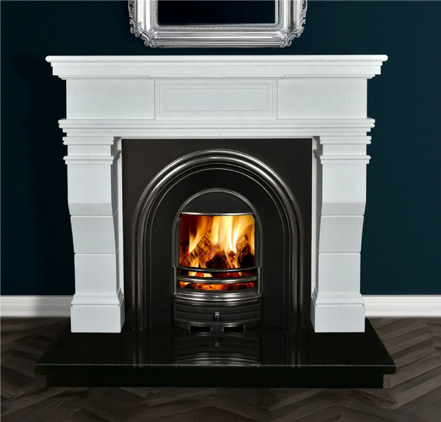 White marble fireplace with black arched insert and real wood fire on dark tile hearth