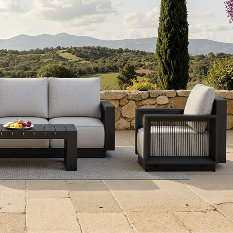 Light grey fabric cushions on black metal frame with slatted black coffee table outdoors