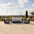 Black metal framed outdoor sofa set with light grey cushions on stone patio | Home Centre Direct UK