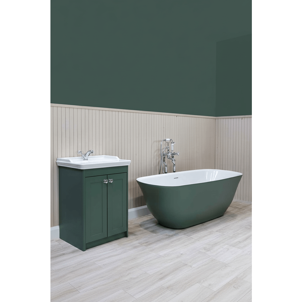 Bathroom with green freestanding bathtub and matching cabinet against a green wall.