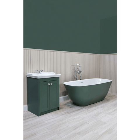 Bathroom with green freestanding bathtub and matching cabinet against a green wall.