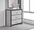 A modern three-drawer chest of drawers with a white finish and dark gray frame, styled in a bright, contemporary room next to a window.