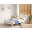 A single bed frame in a White finish, styled with cream bedding and a brown patterned throw blanket in a bright, modern bedroom setting with wooden blinds and a potted plant.